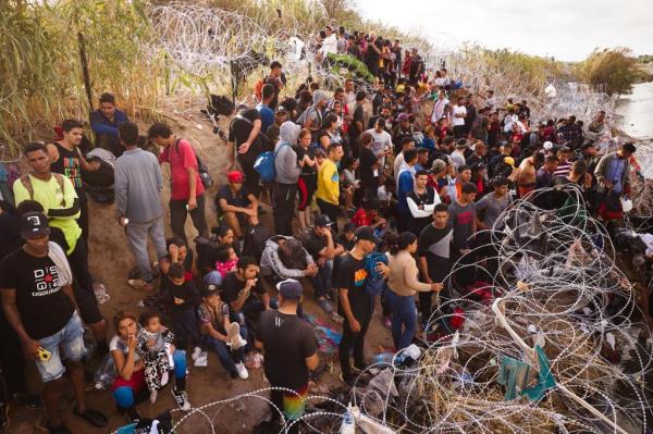 Migrants crammed together at a border fence in Texas  